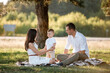 © Andriy Medvediuk - happy family mom dad and baby son happy in nature spending time together on summer sunny day. The concept of a fun holiday outdoors. Happy childhood.