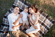 © Andriy Medvediuk - Mom, dad and little son lying on the blanket in the summer park. The concept of summer holiday. Mother's, father's, baby's day. Family spending time together on nature. Family look