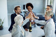 © Drazen - Successful business team gathering hands in unity while celebrating in the office.