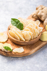 Wall Mural - Slices of ginger dried fruit  and ginger root on a stone table. Against viruses and diseases. immune product.