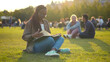 Happy african student lady reading book outdoors in park