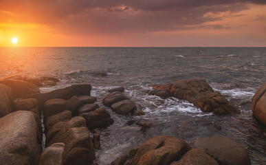 The rock in the sea with dark cloud sky.