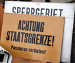 Schild auf einem Flohmarkt: Achtung Staatsgrenze! Passieren verboten!