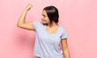 pretty young woman feeling happy, satisfied and powerful, flexing fit and muscular biceps, looking strong after the gym