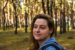 © kavunchik - Tourist with a backpack and a hood at evergreen pine forest. Travel, ecotourism, ecology concept, natural background with an explorer in hoodie and coniferous trees