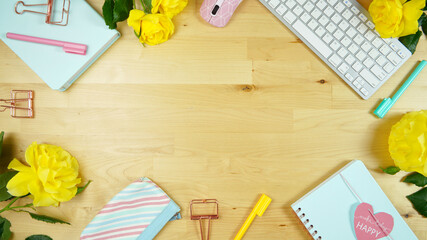 Wall Mural - Modern feminine pink, blue and yellow theme desktop workspace with yellow roses on stylish pale wood background. Top view blog hero header creative composition flat lay. Negative copy space.