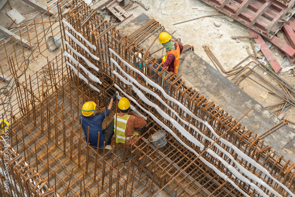 Aerial view of busy industrial under construction site workers working ...