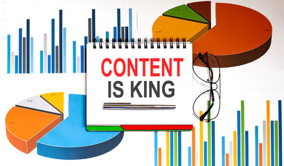 Poster - CONTENT IS KING text on the notepad on chart background with pen and glasses