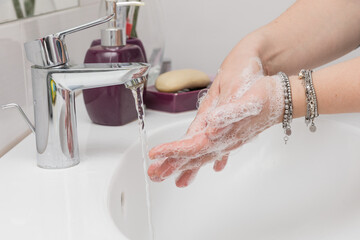  A person washes their hands thoroughly with soap and water to disinfect any bacteria and viruses such as covid-19.