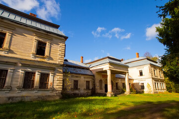 Old ruined historical house in golden autumn fall park