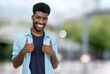 Cheering young adult man from Africa with beard and casual clothes