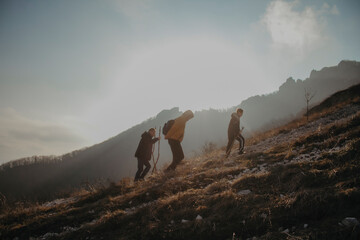 Travelers climb the mountain. Trekking at sunset.