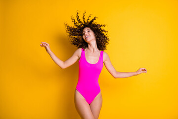 Wall Mural - Photo of attractive overjoyed lady pleasant sun rays exotic resort eyes closed wavy hairdo flight warm breeze relaxation wear pink swimsuit isolated bright vivid shine yellow color background