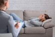 © Prostock-studio - Depressed young woman lying on couch and crying in psychologist's office