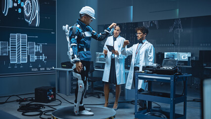 Poster - In Robotics Development Laboratory: Engineers and Scientists Work on a Bionics Exoskeleton Prototype with Person Testing it. Designing Wearable Exosuit to Help Disabled People, Warehouse Workers