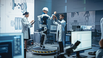 Poster - In Robotics Development Laboratory: Engineers and Scientists Work on a Bionics Exoskeleton Prototype with Person Testing it. Designing Wearable Exosuit to Help Disabled People, Warehouse Workers