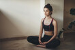 © Strelciuc - Caucasian woman in activewear is meditating on the floor while doing home gym exercises