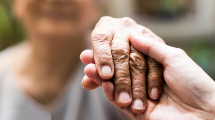 Geriatric doctor or geriatrician concept. Doctor physician hand on happy elderly senior patient to comfort in hospital examination room or hospice nursing home or wellbeing county.