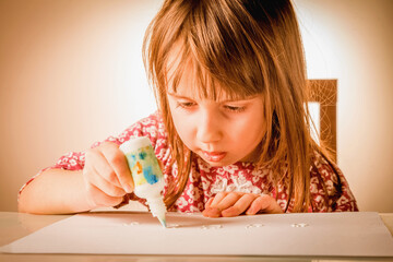 Cute youung girl painting on a white paper. Creativity, education, child development in art concept.