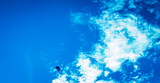 Fototapeta Kosmos - flying high in the sky, paraglider up in the air with a blue sky some clouds and copy space 