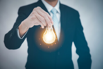 Poster - Businessman hold the light bulb in graph Screen Icon of media screen,Technology Process System Business concept.