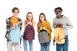 © LIGHTFIELD STUDIOS - Smiling multicultural teenagers holding backpacks and looking at camera isolated on white