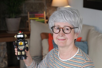 Senior man holding small robot
