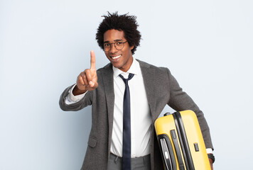 Wall Mural - young black afro man smiling proudly and confidently making number one pose triumphantly, feeling like a leader