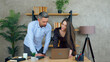 © viacheslav - Smiling woman and man employees working together in an office preparing presentation for meeting. Manager shows report to businessman on laptop computer