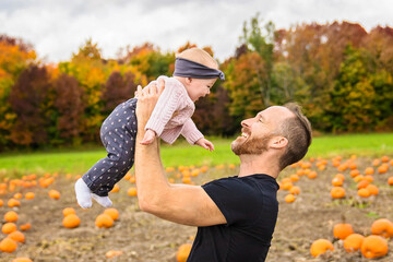 father and daughter on a field with pumpkins