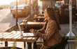 © Petryshak - Close-up of young professional business woman using her laptop outside while working at modern business center, modern buildings in the background.