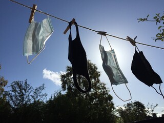 face masks on washing clothes line reusable and washed masks for protection on face from coronavirus covid-19 pandemic