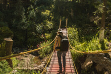 Boy Scout, On A Suspension Bridge In The Middle Of The Forest, Carrying A Backpack