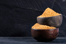Organic brown sugar in two wooden bowls - Saccharum officinarum