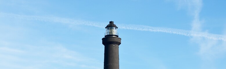 Wall Mural - White lighthouse of Ile de Sein in Brittany, France. Clear blue sky with cirrus clouds. Panoramic view. Idyllic landscape. Travel destinations, tourism, sightseeing, landmarks, vacations