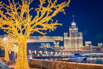 Wall Mural - New Year Moscow. The soaring bridge and the Stalinist high-rise are festively lit. View from the embankment of the Moscow river to the city center. Christmas in the capital of Russia.