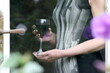 Mature woman holding a glass of red wine as seen through glass door.