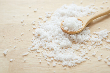 Salt in wooden spoon on the kitchen table  and copy space