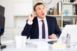 © JackF - Thoughtful concentrated businessman working alone in office with laptop and papers