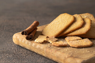 Wall Mural - Stack of Cinnamon sugar  crackers on wooden plate on background.