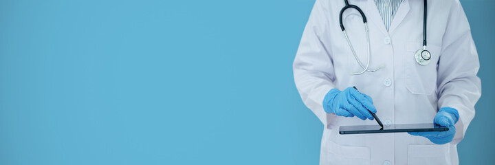 Medical doctor checking result on digital tablet with empty blue background.