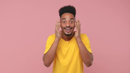 Sticker - Side profile view of surprised young african american man 20s in yellow t-shirt posing isolated on pink background in studio. People lifestyle concept. Turn around camera say wow doing winner gesture