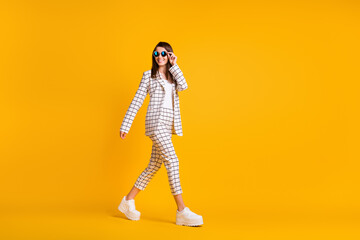 Wall Mural - Full length body size side profile photo of girl wearing black sunglass walking smiling isolated on bright color background with empty space