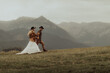 Beautiful stylish  couple walks holding hands in a Carpathian mountain landscape.