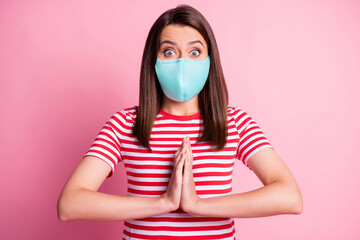 Poster - Photo portrait of cute charming young lady holding pleading hands wearing blue fabric face mask isolated on pastel pink colored background