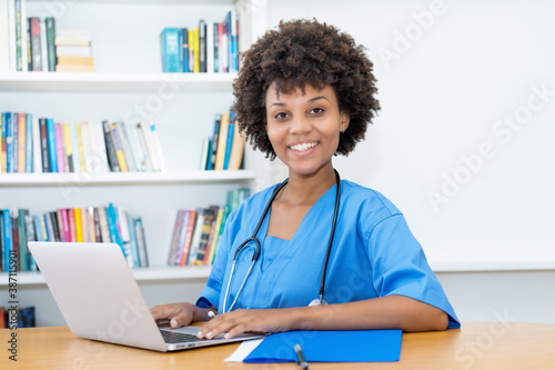 Laughing afro american nurse or medical student at computer