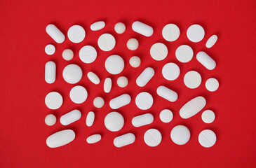 Wall Mural - Bright red background with white medicine tablets