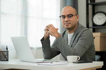 a man around the age of 35. working at home by meeting video conference looking at camera. he was we