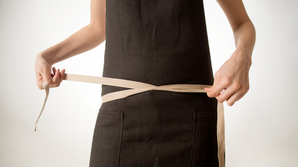 Wall Mural - Chef, cook or baker woman. young girl tying apron