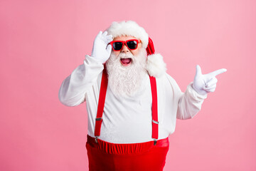 Wall Mural - Amazed beard fat santa claus enjoy x-mas newyear christmas discount ads point finger touch sunglass wear style stylish trendy headwear suspenders overalls isolated pastel color background